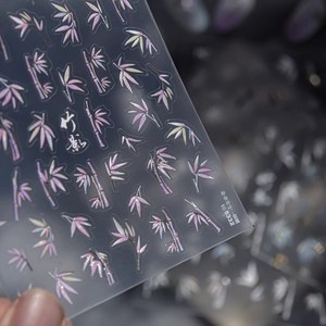 Macro detail of metallic bamboo leaf nail stickers with iridescent pink and white finish