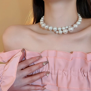 Close-up of double-layered white pearl necklace with gradient beads worn by a model