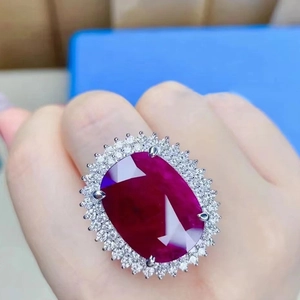 Elegant silver halo ring with large oval red gemstone and white crystal accents on hand