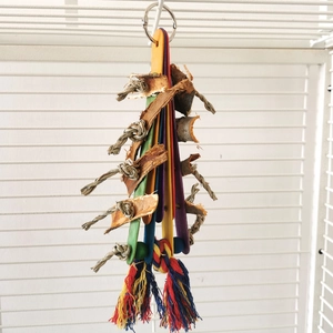 Close-up of bird toy featuring colorful wood pieces and natural bark on hemp rope