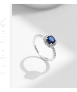 Macro detail of silver halo ring featuring a deep blue sapphire-like stone and side diamonds