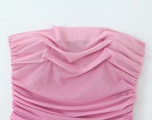 Dettaglio del tessuto a rete rosa con design increspato e trama elastica sull'abito