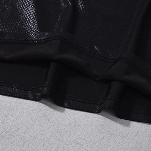 Detalle de chaleco de piel sintética negra mostrando textura de serpiente y forro interior