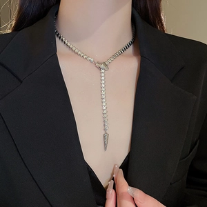 Chic silver snake-style Y-necklace with metallic drape on model in black suit