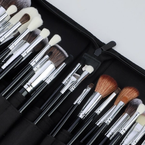 Detail of 30-piece professional makeup brush set in a black zippered storage roll bag