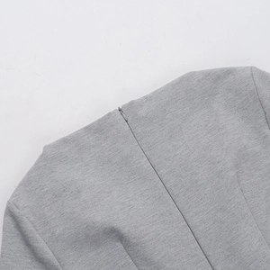 Close-up of the high-quality invisible back zipper on a slim grey knit autumn dress