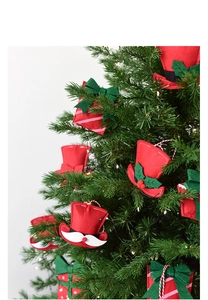 Close-up of red felt hat and gift box ornaments hanging on a green Christmas tree