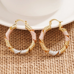 Three-tone twisted hoop earrings featuring gold, silver, and pink metallic textures