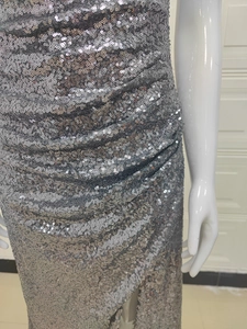 Détail de la robe à paillettes argentées avec effet plissé et texture scintillante