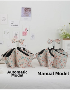 Detail of automatic and manual folding umbrellas with floral patterns and bow handle charms