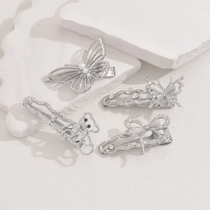 Set of 4 silver butterfly and bear hair clips with rhinestones and pearls on white background