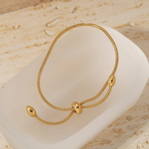 Minimalist gold adjustable snake chain bracelet with sliding clasp on stone texture