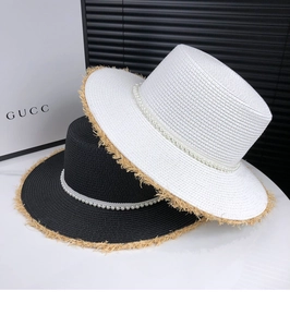 Detail of flat top straw sun hats with elegant pearl trim and frayed brim edges