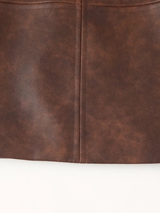 Gros plan détaillé sur la texture du similicuir marron et les coutures de la veste