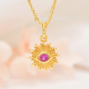 Golden necklace with evil eye sunflower pendant featuring a central pink gemstone