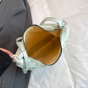 Light green pleated shoulder bag with yellow lining shown from a 45-degree top view
