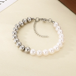 Detail of beaded bracelet with white pearls and polished silver beads on warm background