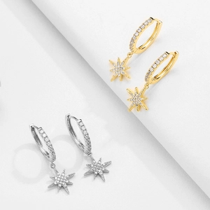 Detail of gold and silver star drop hoop earrings with cubic zirconia pave settings