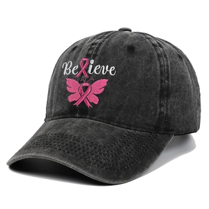 Detail of embroidered Believe text and pink ribbon butterfly on washed denim baseball cap