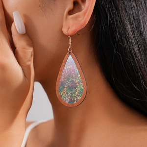 Close-up of bohemian wood teardrop earrings with floral pattern on a female model