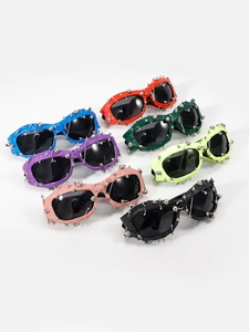 Detail view of colorful punk sunglasses featuring metal studs and spikes on frames