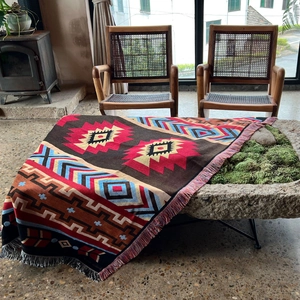 Detailed close-up of Bohemian knit blanket with colorful geometric patterns and long tassels
