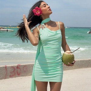 Detail of mint green ruched mini dress with golden star charm and neck tie detail