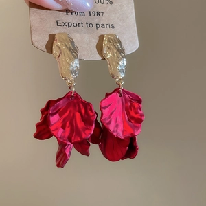 Macro shot of red acrylic flower petal tassel earrings with gold-toned metal accents