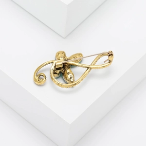 Detailed back view of vintage gold musical note brooch showing secure pin fastener