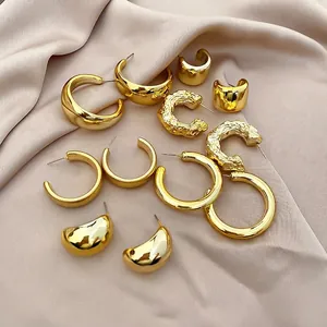 Detailed view of a 12-piece gold hoop earring set on elegant champagne satin fabric