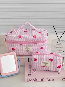 Detailed set of two quilted cotton strawberry makeup bags with pink stripes and handles