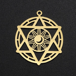 Macro view of gold stainless steel celestial pendant with sun, moon, and hexagram