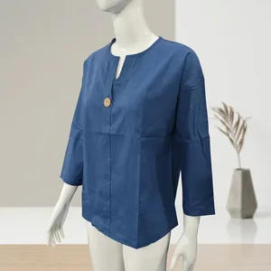 Dettaglio del top blu scuro in cotone e lino con scollo a V e bottone in legno