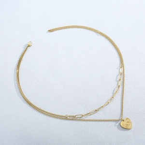 Macro detail of gold-layered necklace featuring a heart pendant with engraved lettering