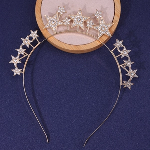 Elegant gold star headband with sparkling crystals on a premium display stand
