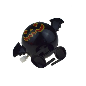 Detail of a wind-up Halloween pumpkin bat toy featuring a black body and spooky face