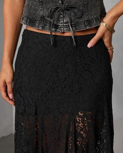 Close-up detail of the intricate floral lace texture on a black mid-waist ankle skirt