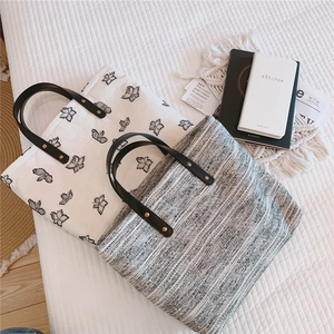 Détail de sacs fourre-tout en toile et tweed avec poignées en cuir sur fond matelassé