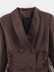 Detail of dark brown double-breasted blazer showing side drawstring and twill texture
