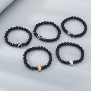 Detail of 8mm black lava stone bracelets with silver and gold metal Buddha heads