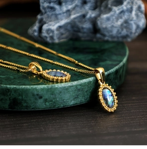 Macro view of 18K gold plated stainless steel necklaces with oval abalone shell pendants