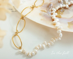 Macro detail of French baroque pearl necklace with golden oval chain on seashell