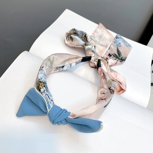 Close-up of floral headband with blue bow detail and elegant long fabric ribbon