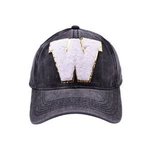 Dettaglio cappello da baseball in denim grigio con lettera W in peluche e oro