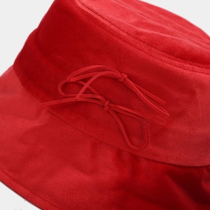 Detailed close-up of red velvet bucket hat featuring a delicate ribbon bow accent
