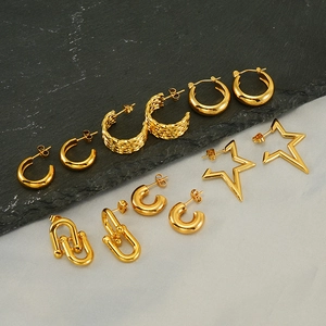 Collection of 18K gold plated stainless steel earrings on a grey stone background