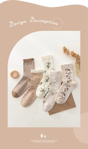 Detailed close-up of five pairs of warm beige cotton socks with floral and plaid patterns
