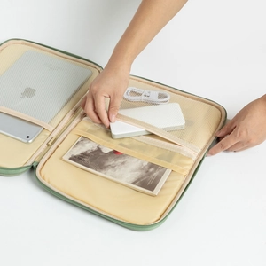 Detail of light green tablet organizer bag showing multi-compartment interior storage