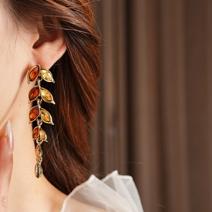 Gros plan de boucles d'oreilles vintage en forme de feuille avec cristaux ambrés