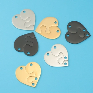 Detailed view of split heart puzzle pendants in gold, silver, and black mirror finish